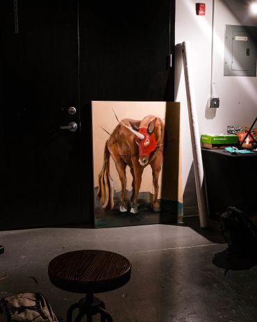 Painting of a bull leaning against a dark door.