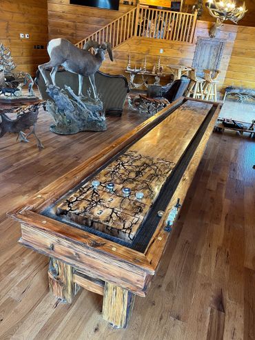 Rustic wooden shuffleboard table in a lodge with wildlife decor.