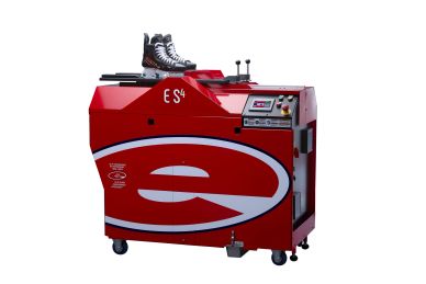 Red ice skate sharpening machine with skates on top.