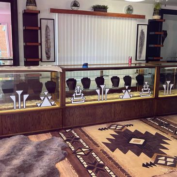 Jewelry display cases with geometric designs in a room with patterned rugs.