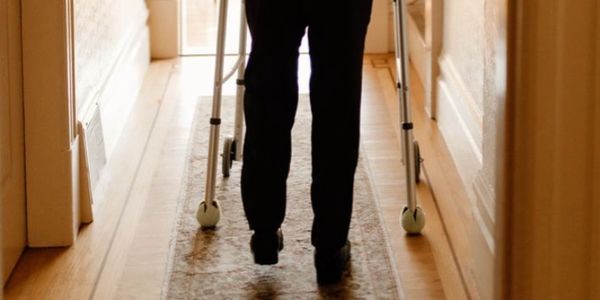 Person walking with a walker indoors.