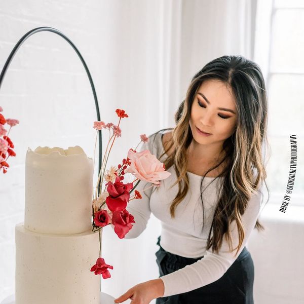 Suzanne owner and wedding cake designer of Bloom Bakehouse Northamptonshire, decorating wedding cakef