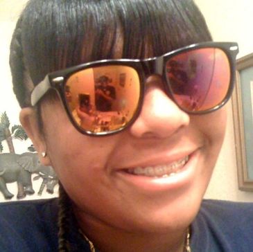 Person smiling with reflective sunglasses and braces.