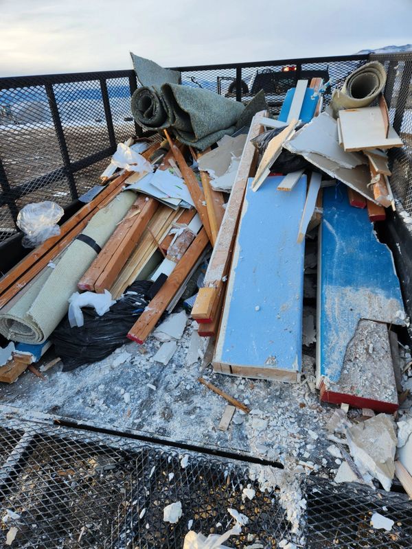 A trailer filled with construction debris and discarded materials outdoors.