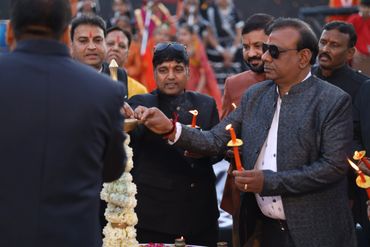 Men lighting candles at a solemn ceremony.