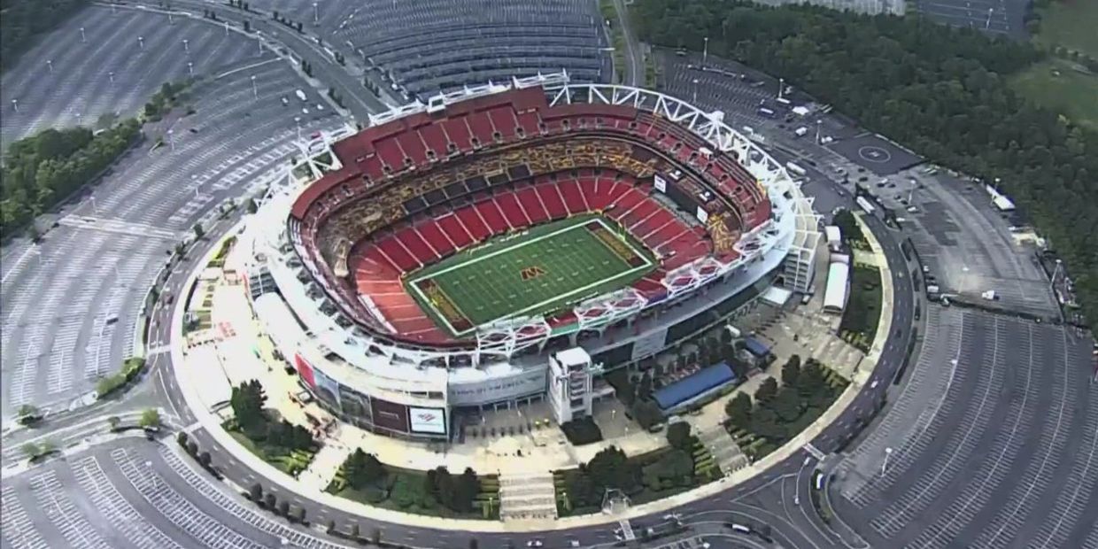 Aerial view of a large football stadium surrounded by empty parking lots.
