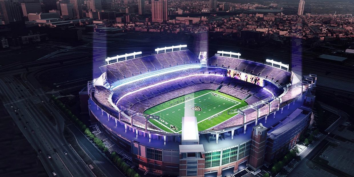 A brightly lit football stadium at night in a bustling city.