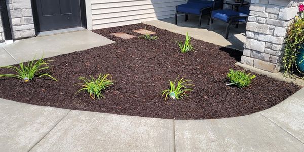 Detailed front entry landscaping with fresh mulch, clean edges, and new plantings