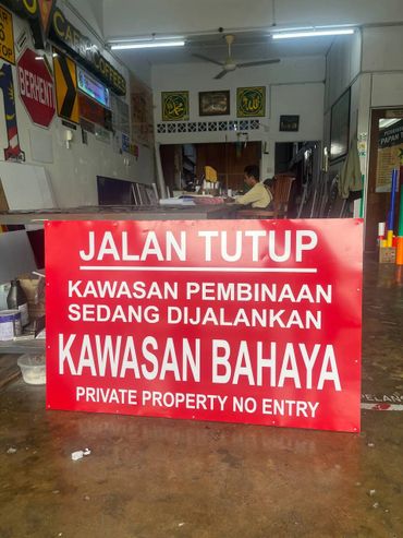 Red sign warns of closed road and danger due to construction, no entry allowed.