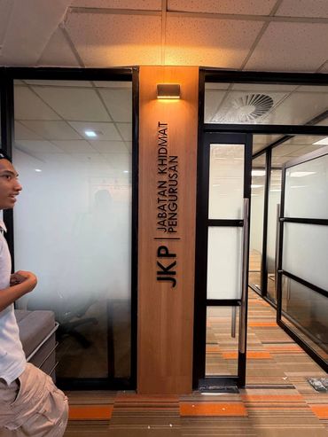Entrance to JKP office with glass doors and a man standing nearby.