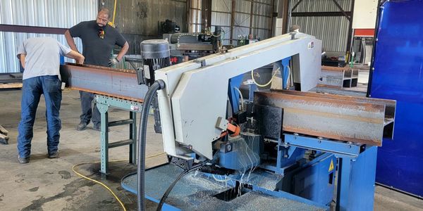 band saw cutting metal H beam