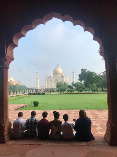 People view Taj Mahal from an arched doorway.