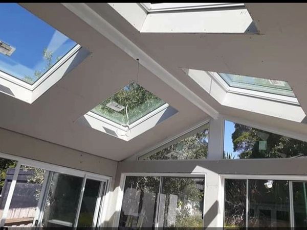 Modern room with multiple skylights and large windows letting in natural light.