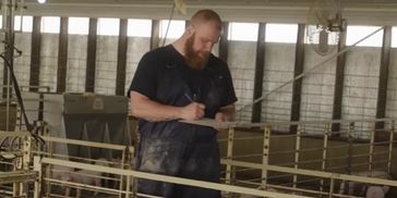 Justin Kleinschmidt, founder of PigPros, working in a swine barn