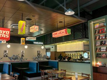 Interior of a modern restaurant with vibrant signage and cozy seating.