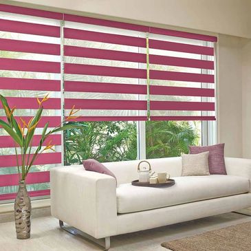 Three Magenta Vision blinds, side by side over bi-fold doors protecting a cream suite and carpet.