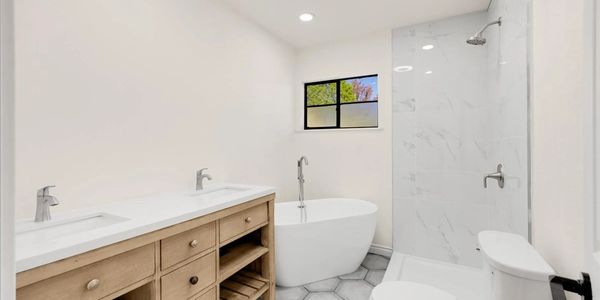 Modern bathroom with double sinks, a freestanding tub, and a walk-in shower.