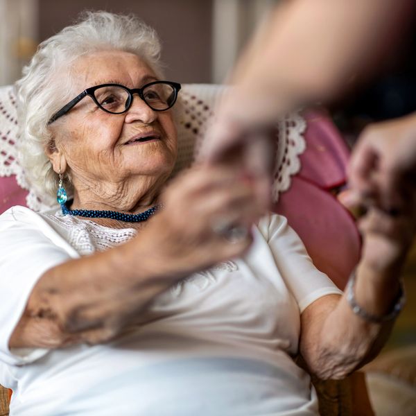 A person holding hands with an elderly woman