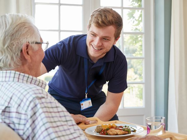 A carer offering a meal to a patient