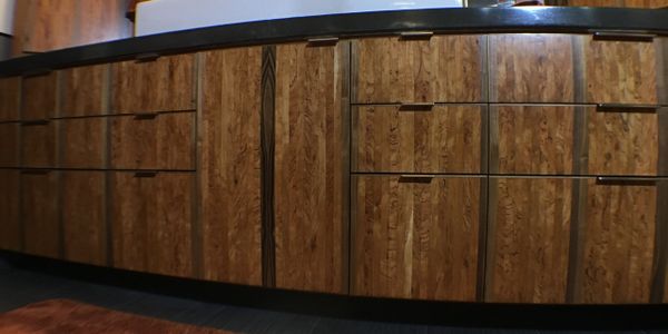 Wooden kitchen cabinets with a natural finish and modern handles.