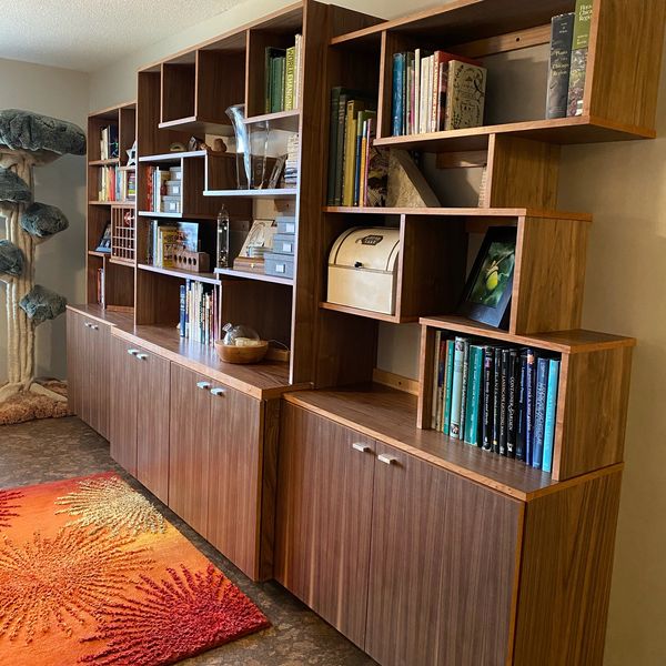 Mid-century modern wooden bookcase with assorted books and decor.