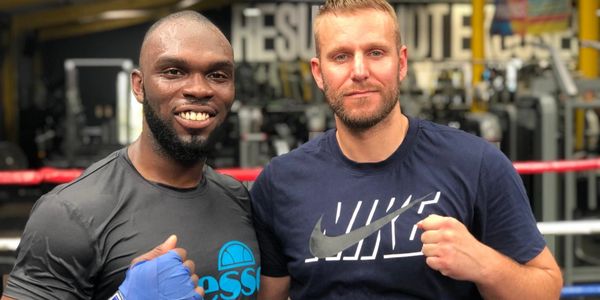 two men posing for a picture holding a fist up