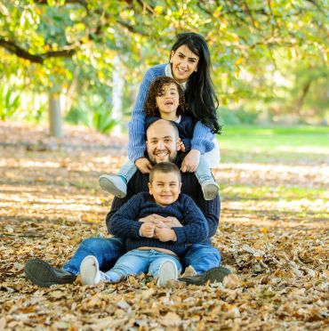 Happy family posing in autumn leaves.