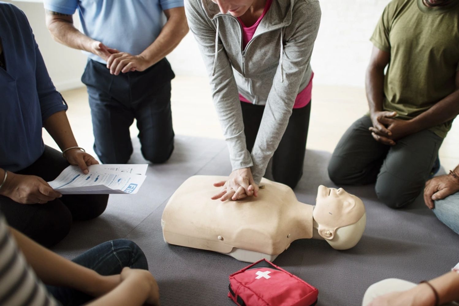 A person doing CPR on a manikin at a CPR class.