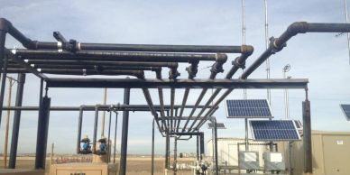 Industrial facility with pipelines and solar panels.