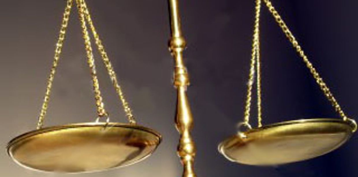 Close-up of a golden balance scale with empty plates.