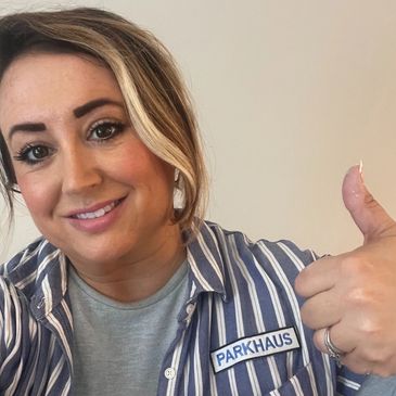 Woman smiling with thumbs up wearing a Parkhaus shirt.