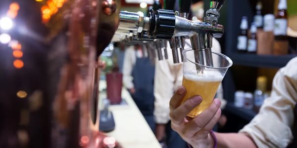 freelancer bartender pouring a beer during flexible work shift