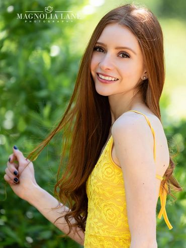 Outdoor portrait photography of a young woman with red hair senior pictures.