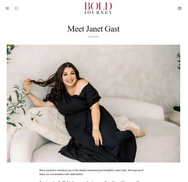 Janet Gast smiles warmly, lounging comfortably on a white sofa in a stylish black dress.