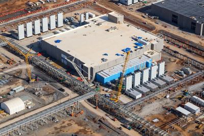 Aerial view of a large industrial facility under construction with cranes and equipment.
