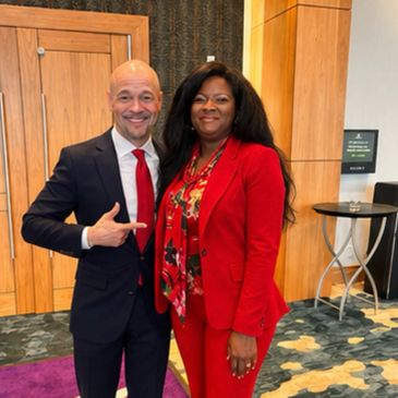 Two people dressed formally, smiling for a photo.