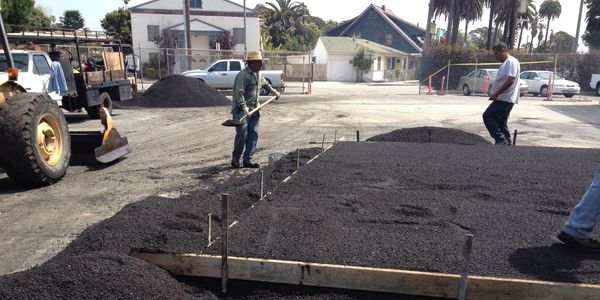 Construction worker working with black sand and cement