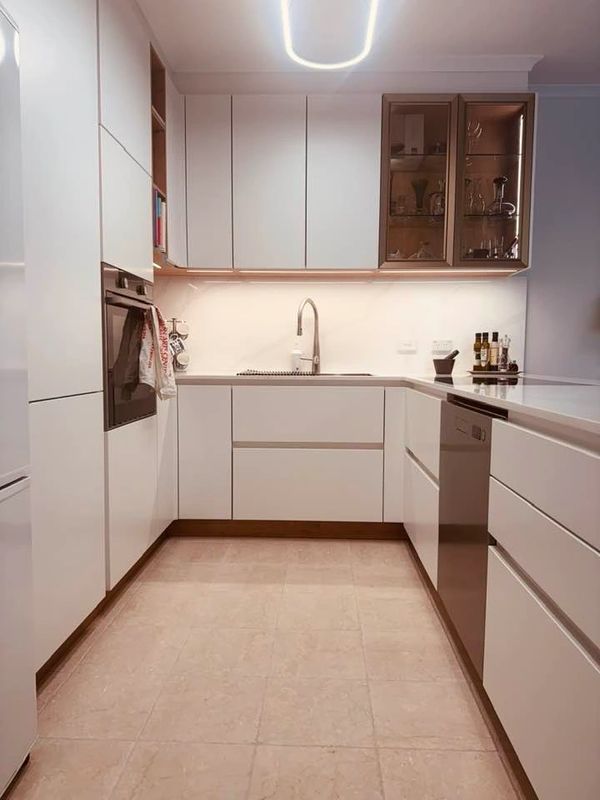 Modern white kitchen with sleek cabinets and appliances.