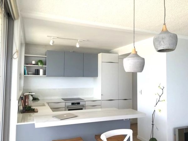 Modern minimalist kitchen with blue cabinets and white countertops.