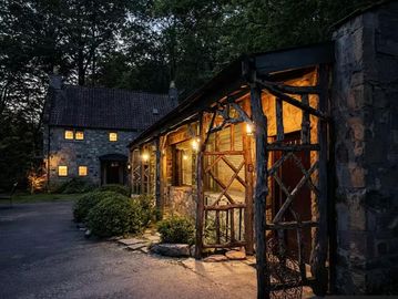 Stone house warmly lit at dusk.