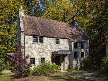 Stone cottage surrounded by trees.