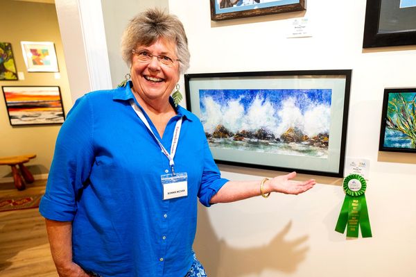 Artist in front of her painting of  rising tide