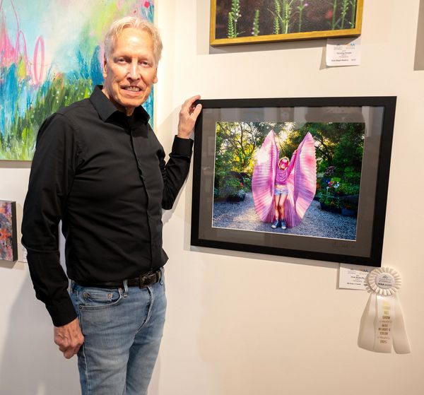 Picture of Artist with photograph of a girl dressed as a Pink Butterfly