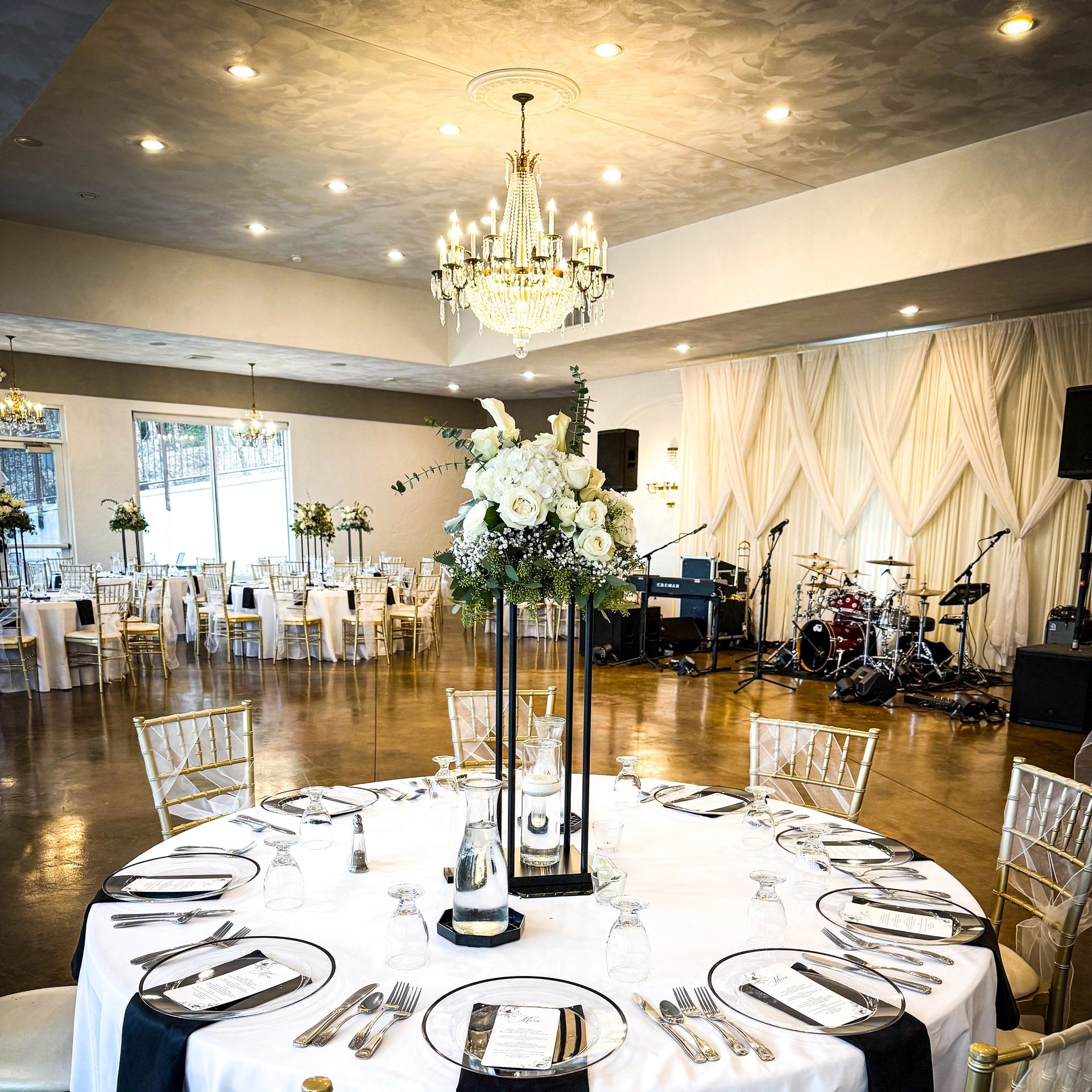 Elegant wedding reception setup with flowers and chandeliers.