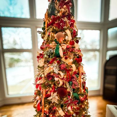 Decorated Christmas tree with red, gold, and green ornaments.