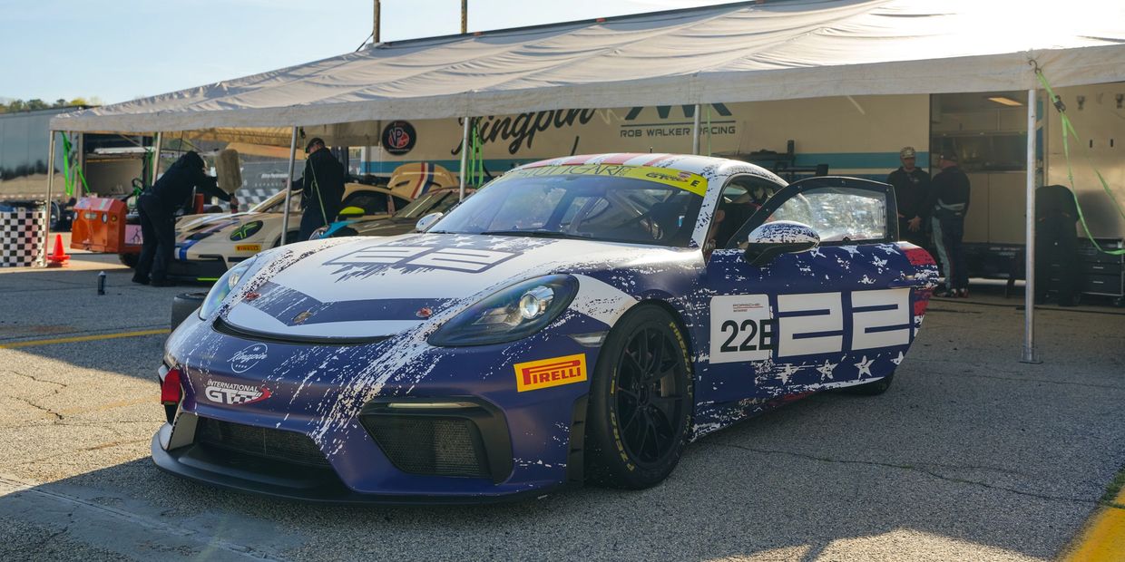 Race car 22 in a blue and white distressed paint design at a race event.