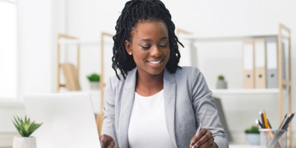 Smiling woman working at a desk in a bright office.