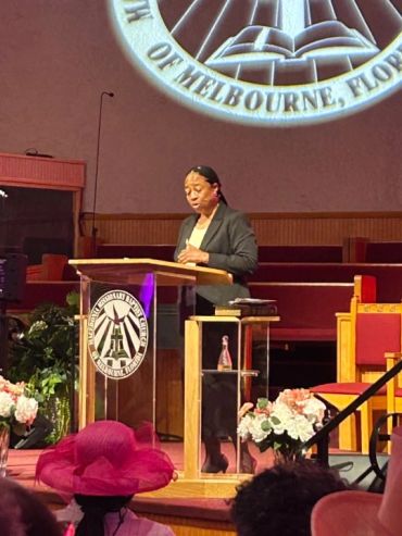 Woman speaking at a church podium.