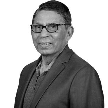 Portrait of a smiling elderly man in glasses and blazer.