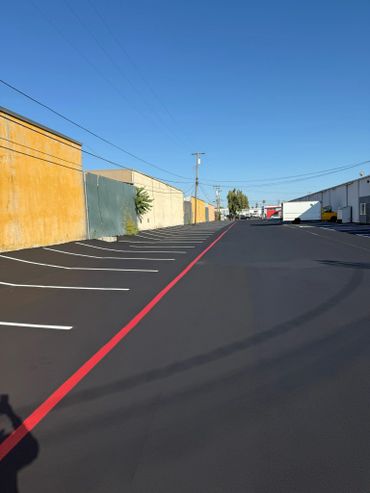 Empty parking lot with freshly painted lines and a clear blue sky.